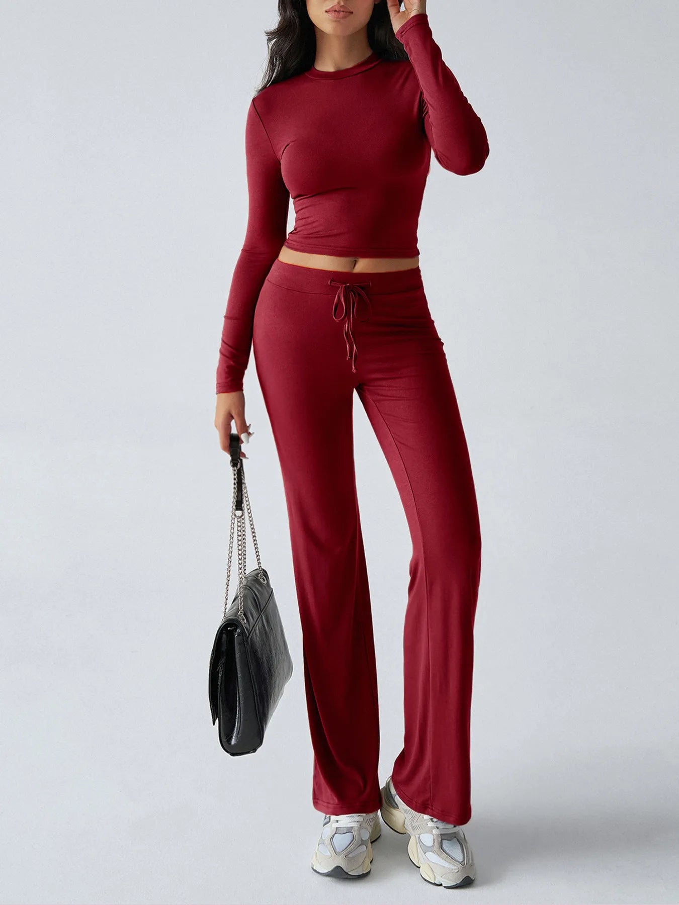 Person wearing a red outfit with a gray handbag on a white background