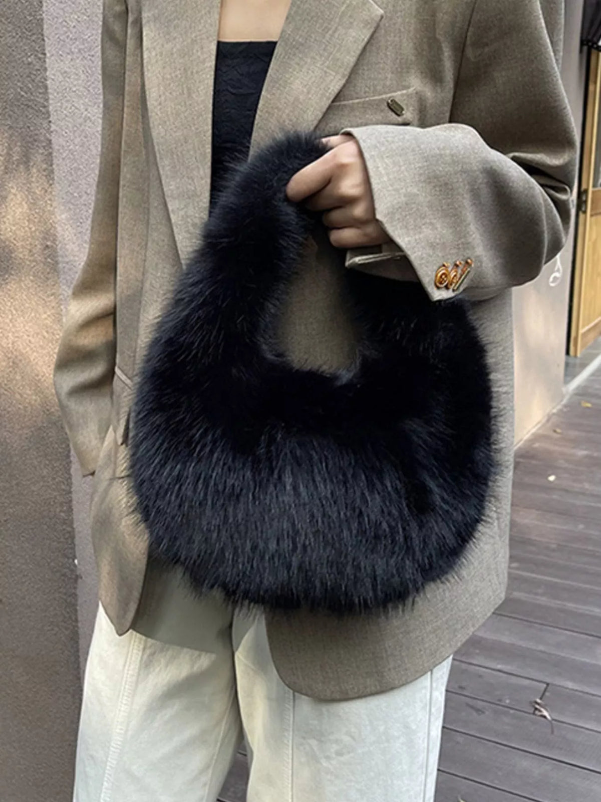 Person wearing a dark blue fur stole over a beige coat.
