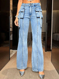 Person wearing high-waisted blue jeans with cargo pockets in a room.