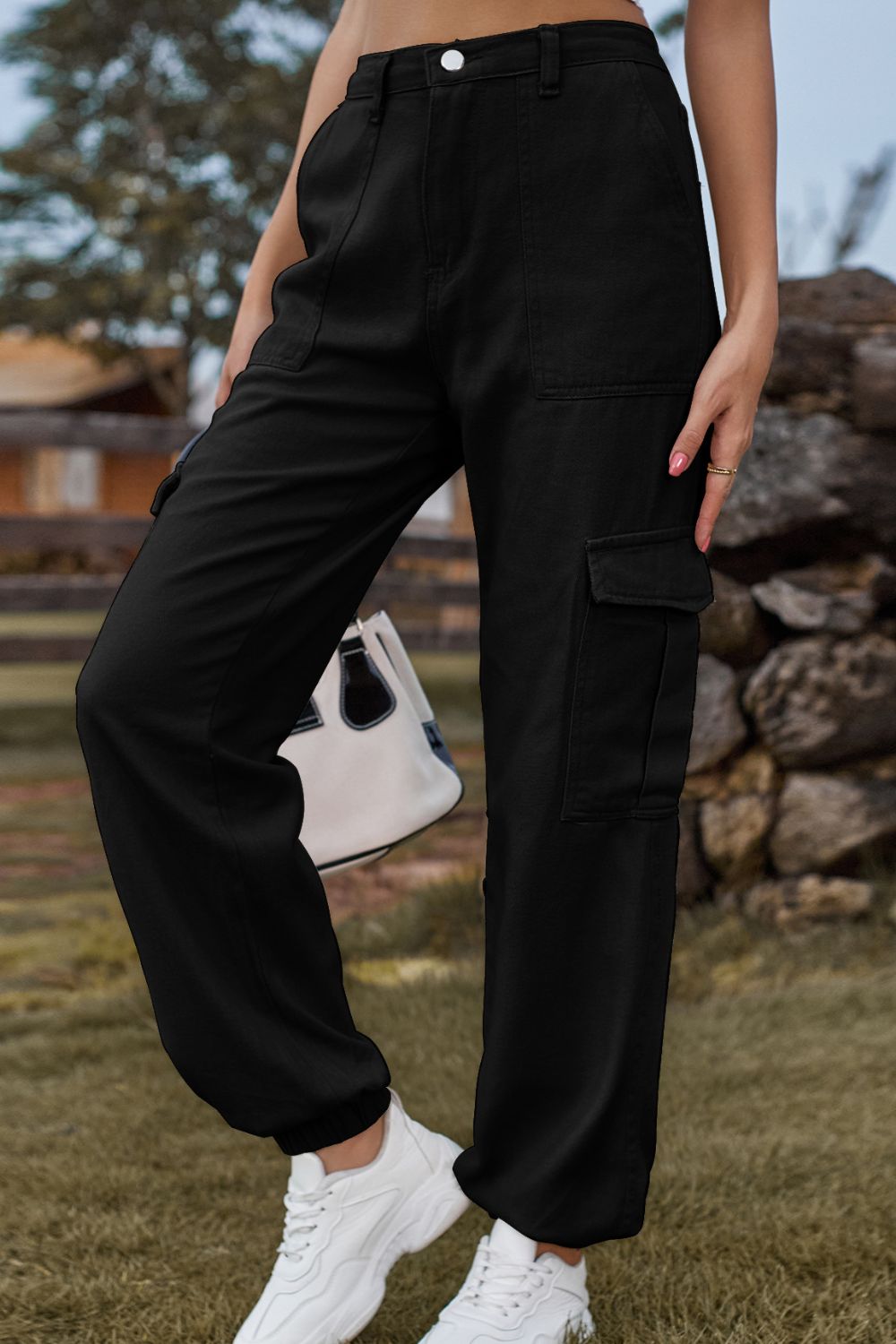 Person wearing black cargo pants with a blurred background