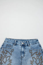 Blue jeans with decorative patterns on a white background