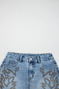 Blue jeans with decorative patterns on a white background