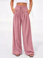 Pink wide-leg pants worn by a person on a white background