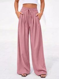 Pink wide-leg pants worn by a person on a white background