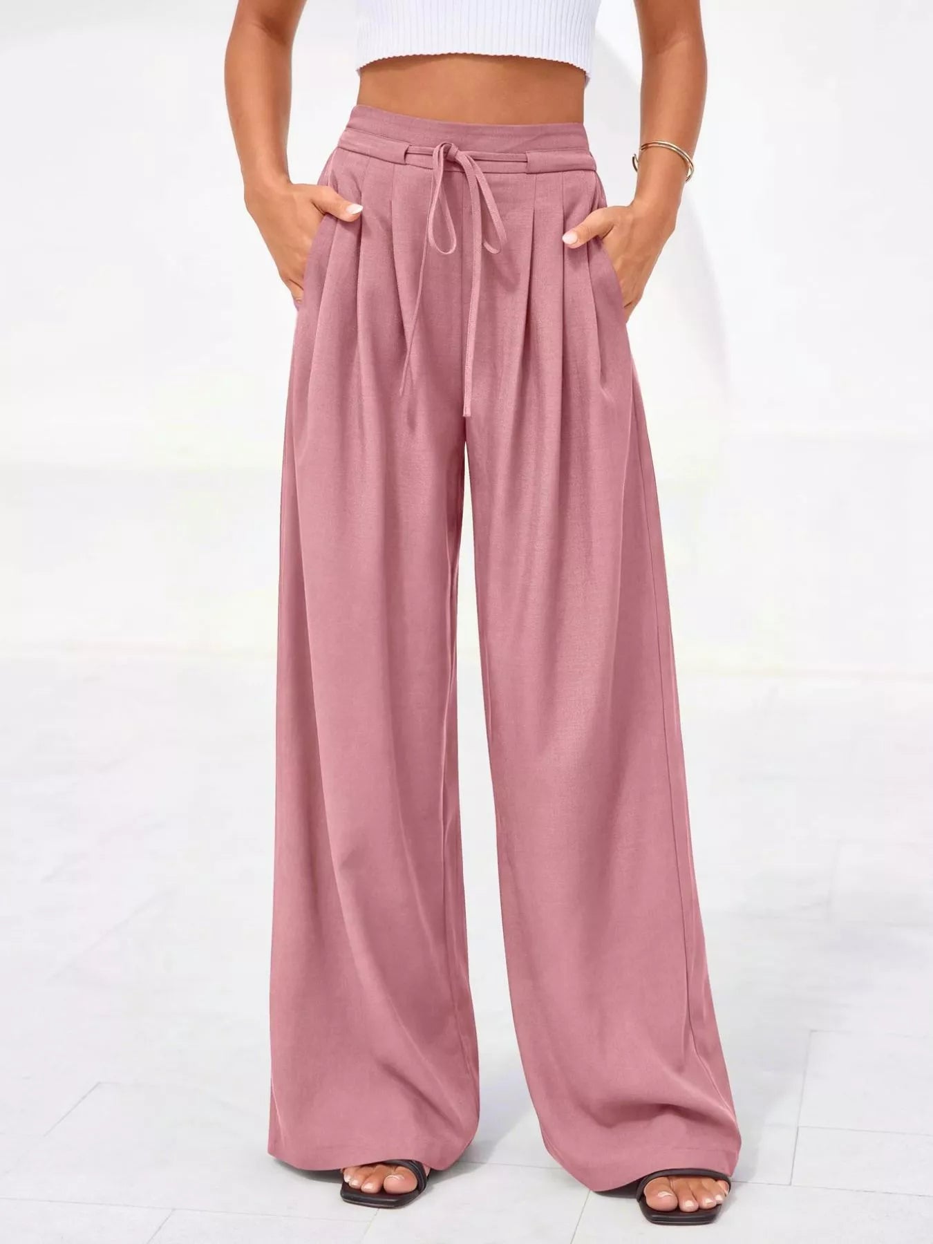 Pink wide-leg pants worn by a person on a white background