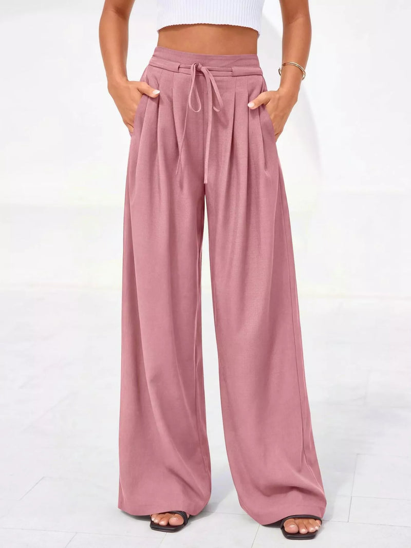 Pink wide-leg pants worn by a person on a white background
