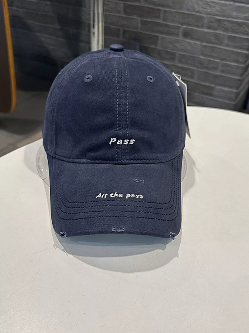 Navy blue cap with text on a white surface and gray background