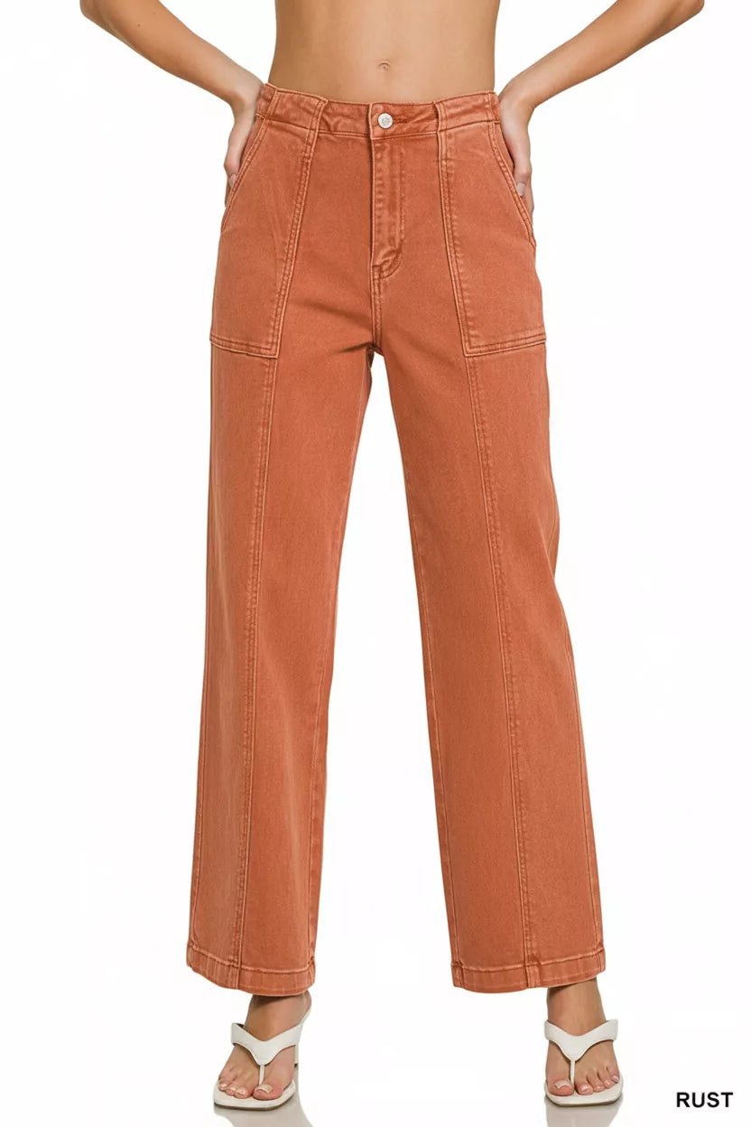 Rust-colored wide-leg jeans worn by a person on a white background