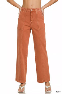 Rust-colored wide-leg jeans worn by a person on a white background