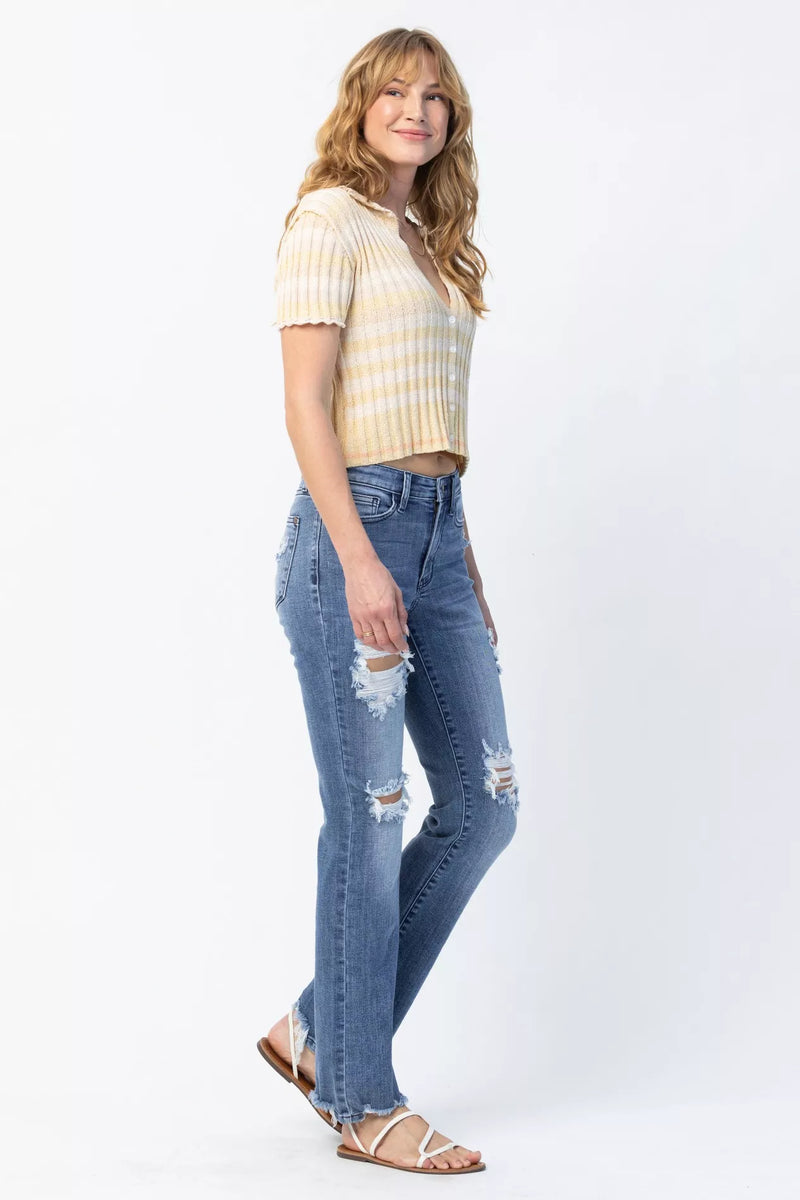 Woman wearing a striped shirt and ripped jeans on a white background