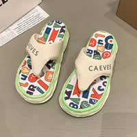 Colorful slippers with letter patterns on a gray surface