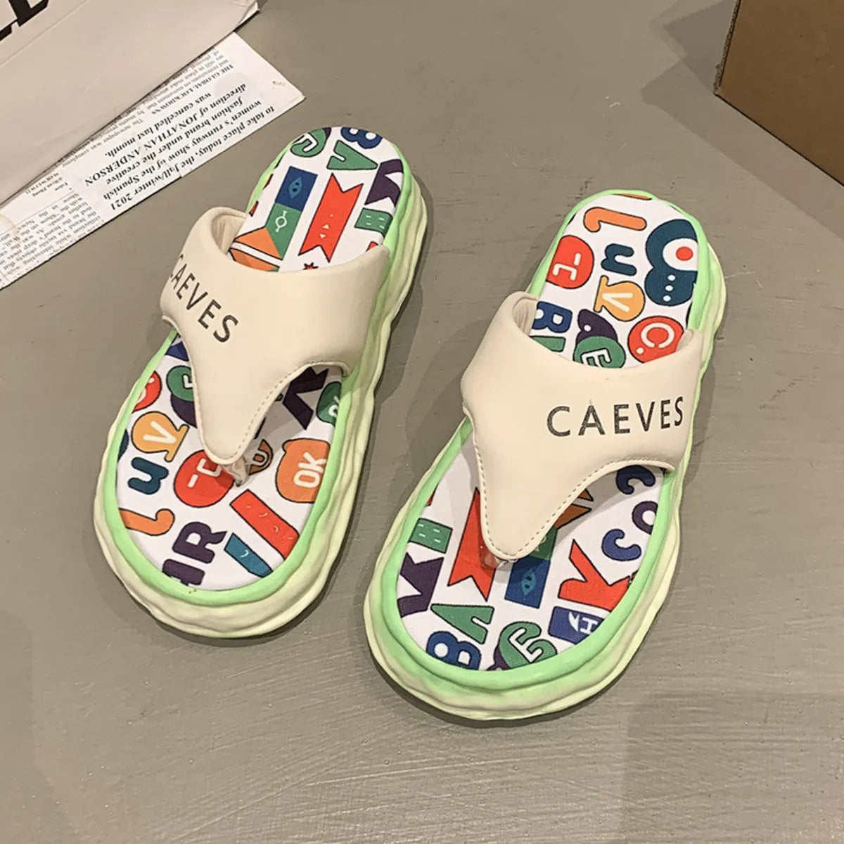 Colorful slippers with letter patterns on a gray surface