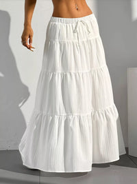 White tiered skirt worn by a person against a plain background