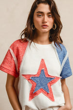 Woman wearing a white shirt with a red and blue star design on a beige background