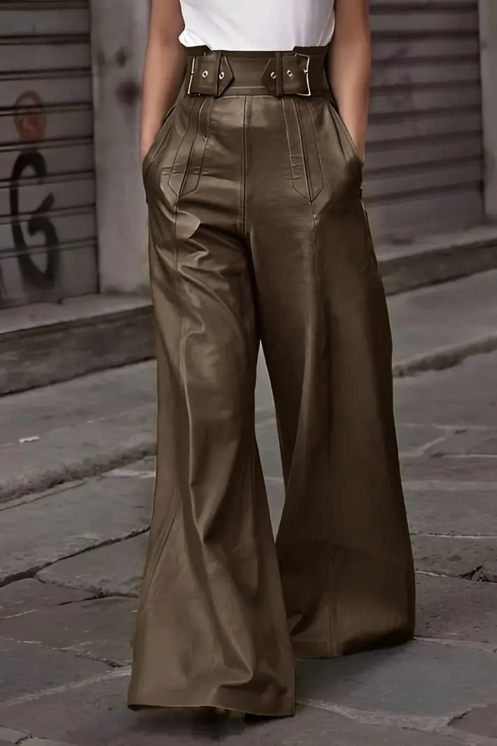 Person wearing brown wide-leg pants on a street with a blurred background