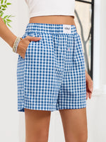 Blue and white checkered shorts worn by a person with a blurred background