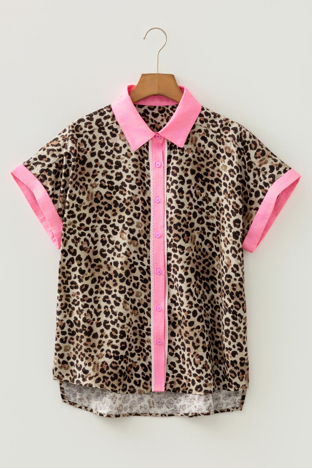 Leopard print dress with pink accents on a wooden hanger against a white background