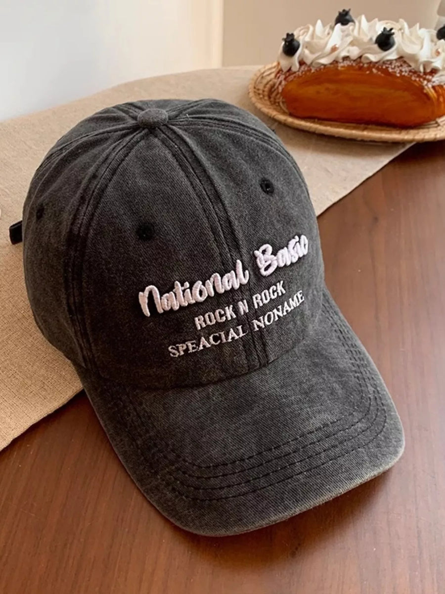 Gray cap with text on a wooden surface with a cake in the background