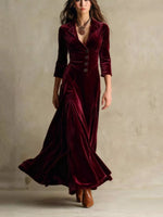Woman wearing a burgundy velvet dress with a plain background
