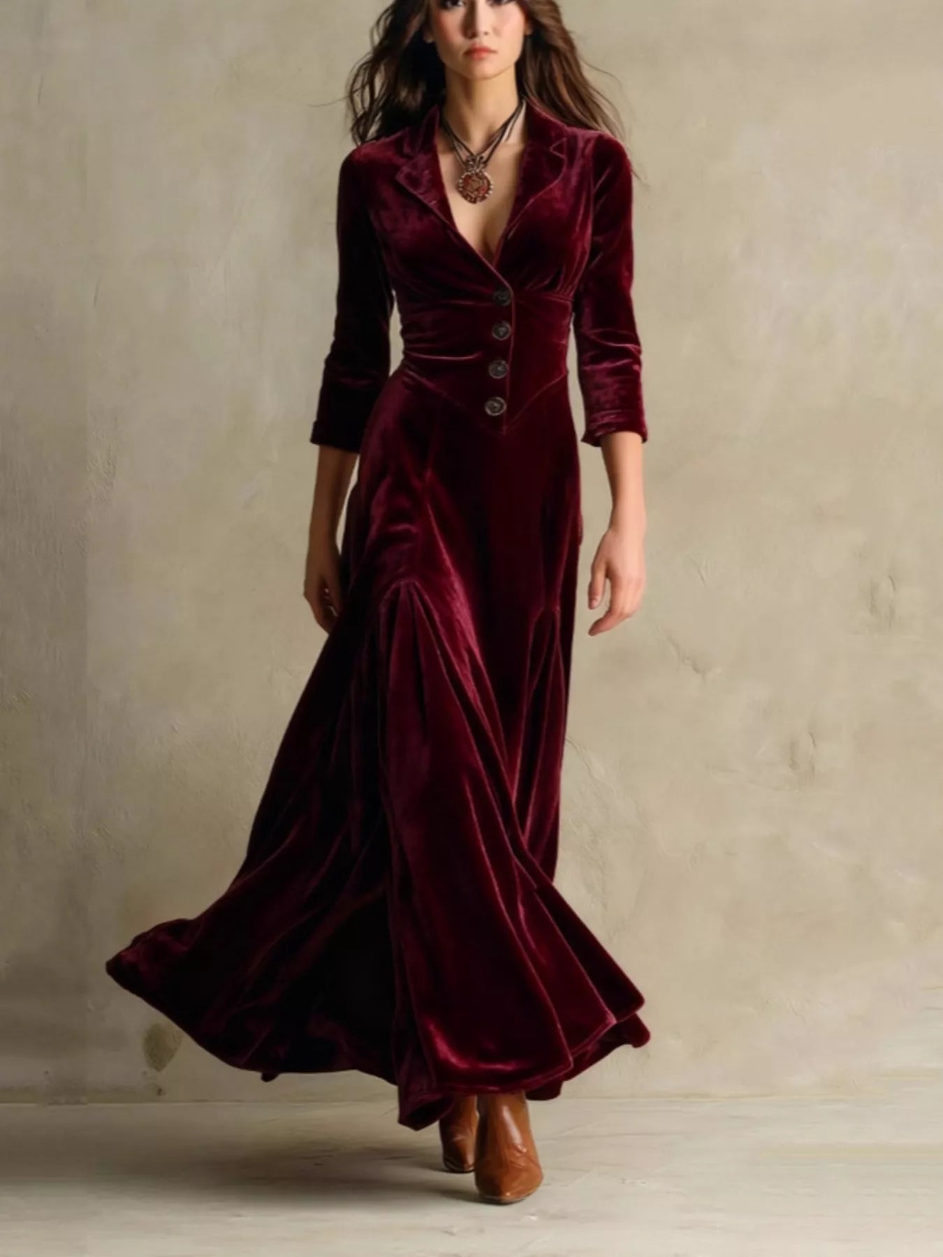 Woman wearing a burgundy velvet dress with a plain background