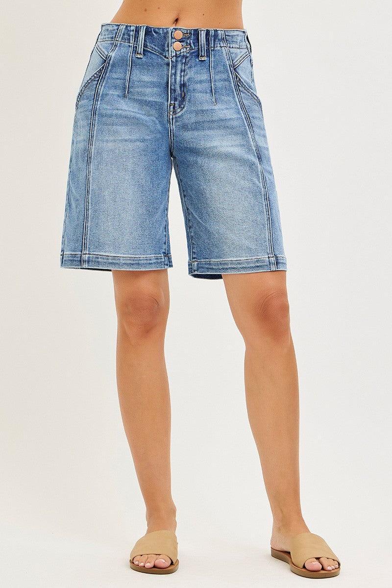 Blue denim shorts worn by a person on a white background