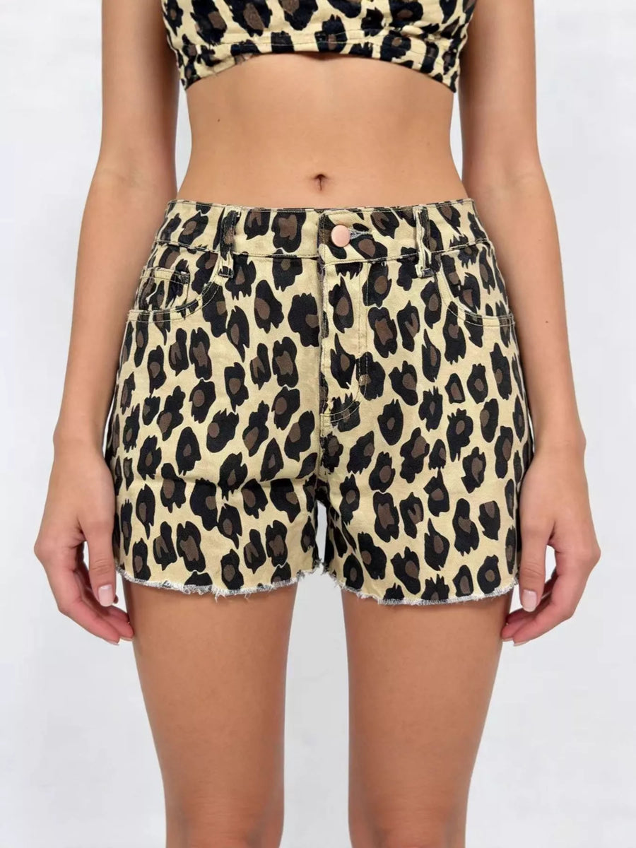 Person wearing leopard print shorts and top on a white background