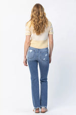 Person wearing blue jeans and a striped shirt on a white background