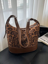 Leopard print handbag on a black surface with a blurred background