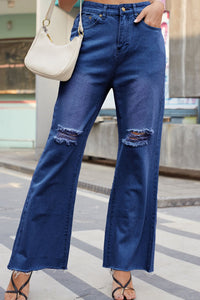 Person wearing blue jeans with a blurred background