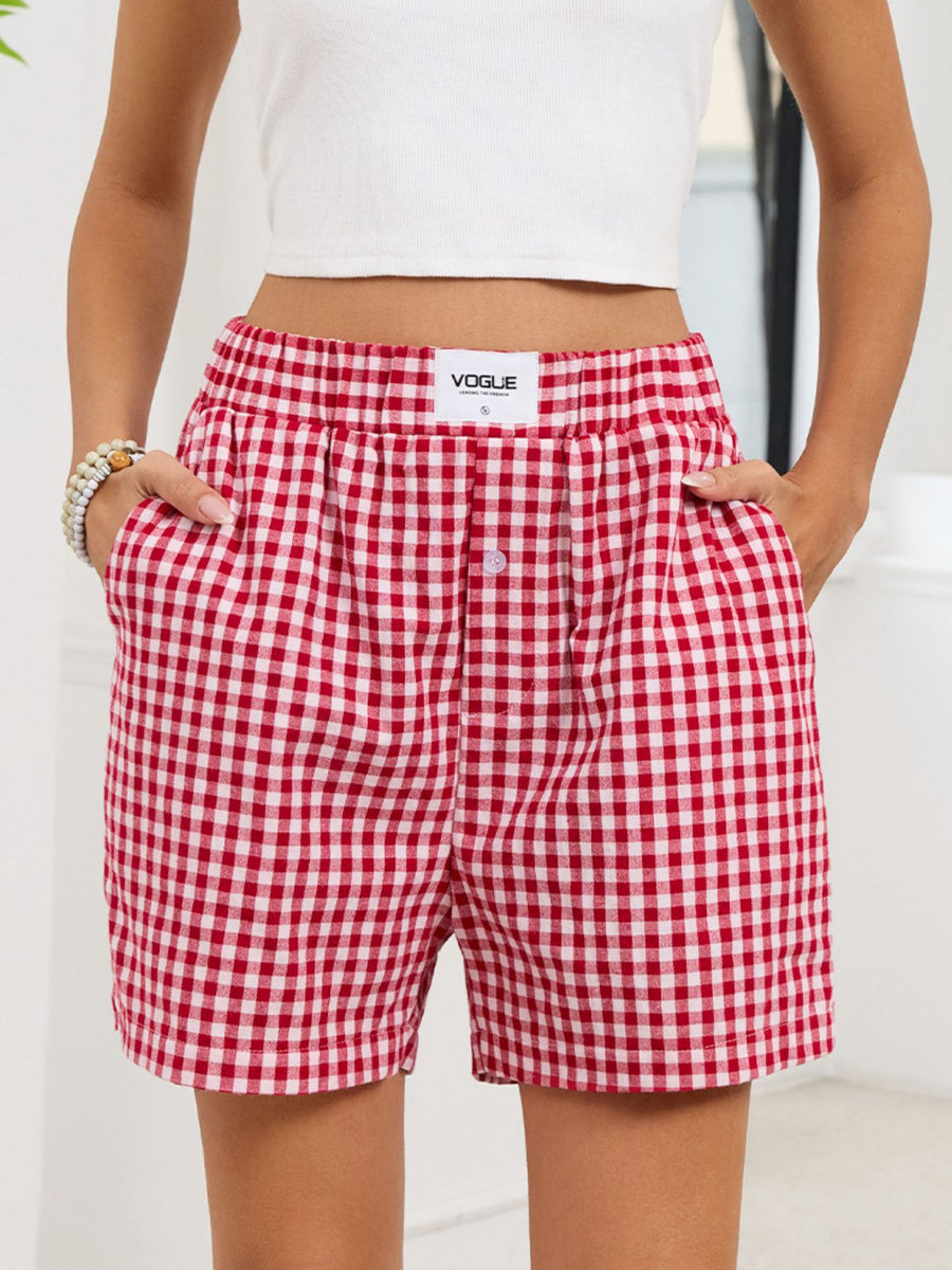 Red and white checkered shorts with a visible 'Vogue' label on a plain background