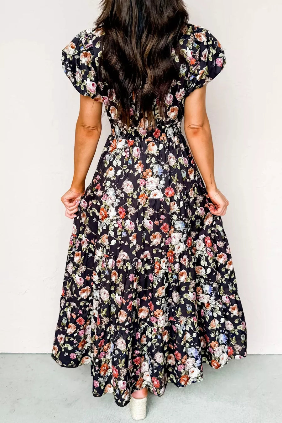 Woman wearing a floral dress with a plain background