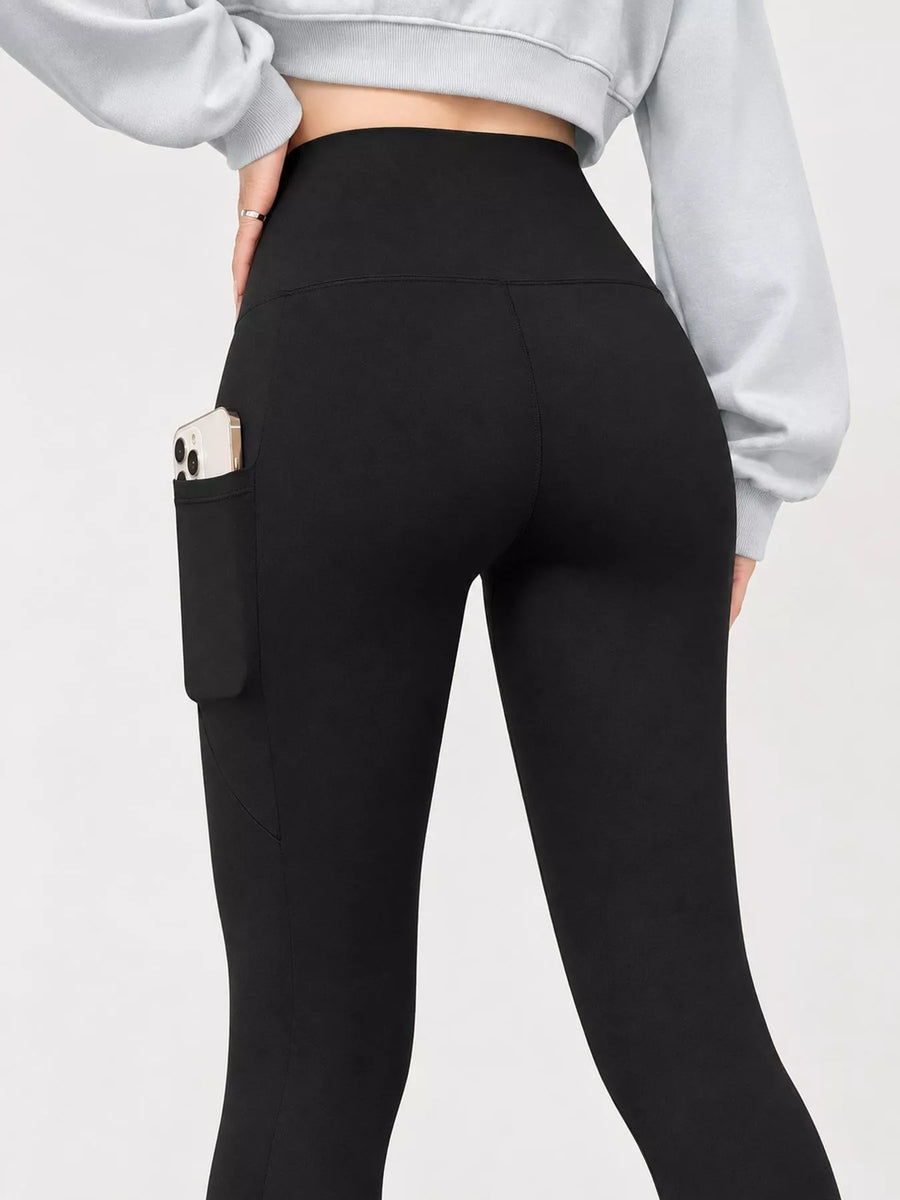 Black high-waisted leggings with a side pocket holding a phone, shown on a model from the back wearing a light gray sweatshirt against a white background.