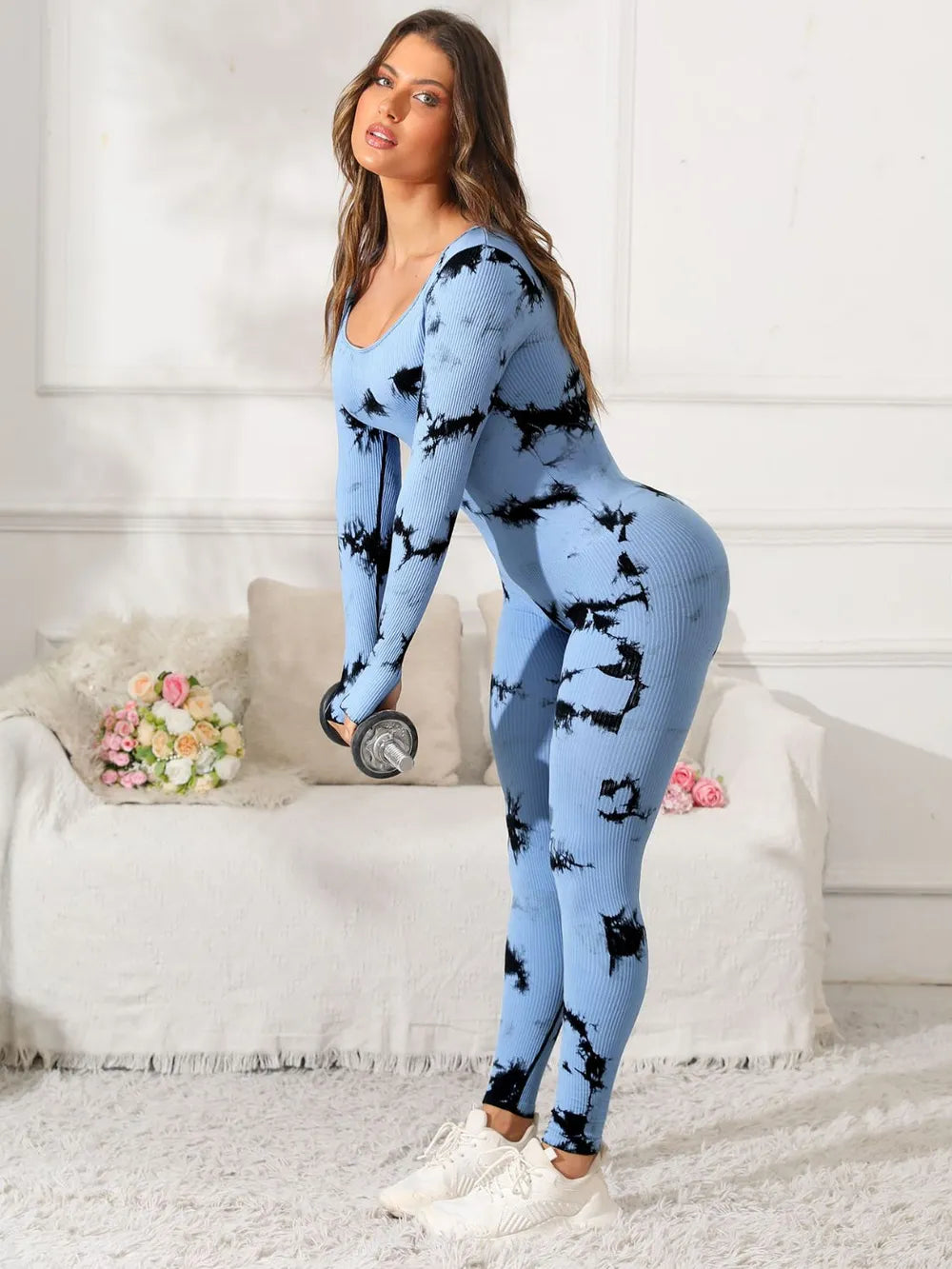 Woman wearing a blue and black tie-dye outfit in a living room setting.