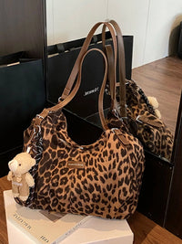 Leopard print handbag with a teddy bear on a wooden surface