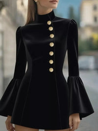Black dress with gold buttons and flared sleeves on a blurred background