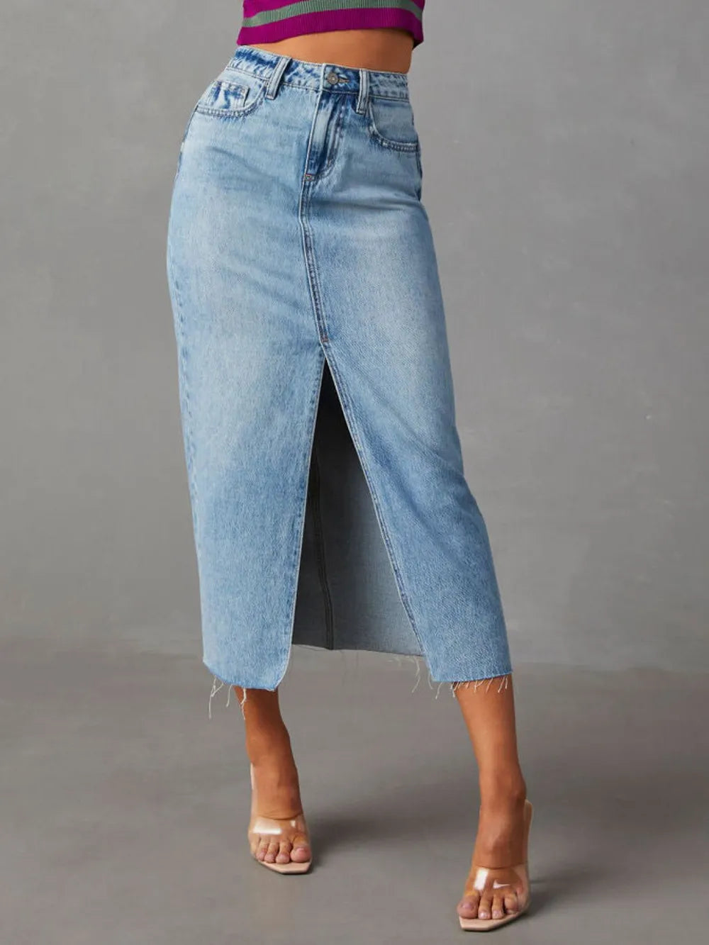 Blue denim skirt worn by a person on a gray background