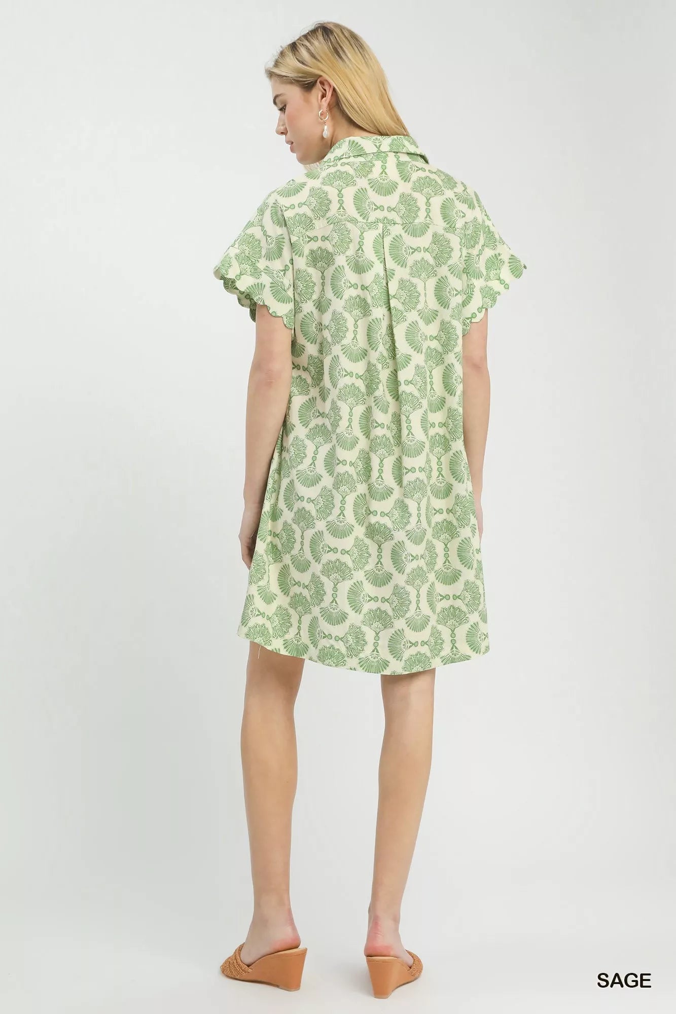 Woman wearing a green patterned dress on a white background