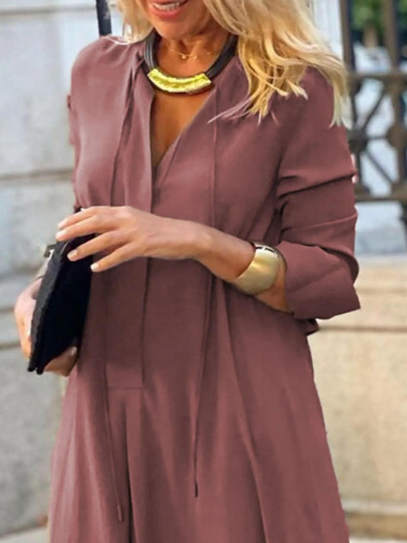 Woman wearing a mauve dress with a blurred background