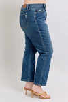 Blue jeans worn by a person on a plain background