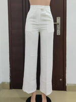White pants displayed on a mannequin against a plain background
