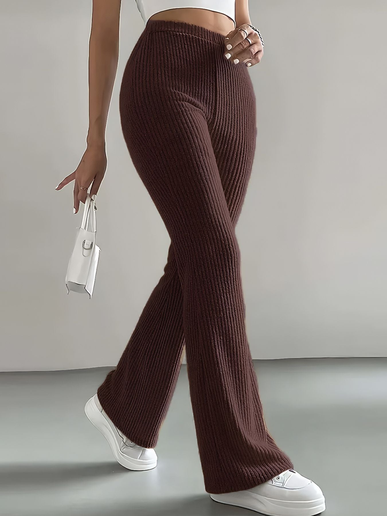 Person wearing brown ribbed pants with a white background