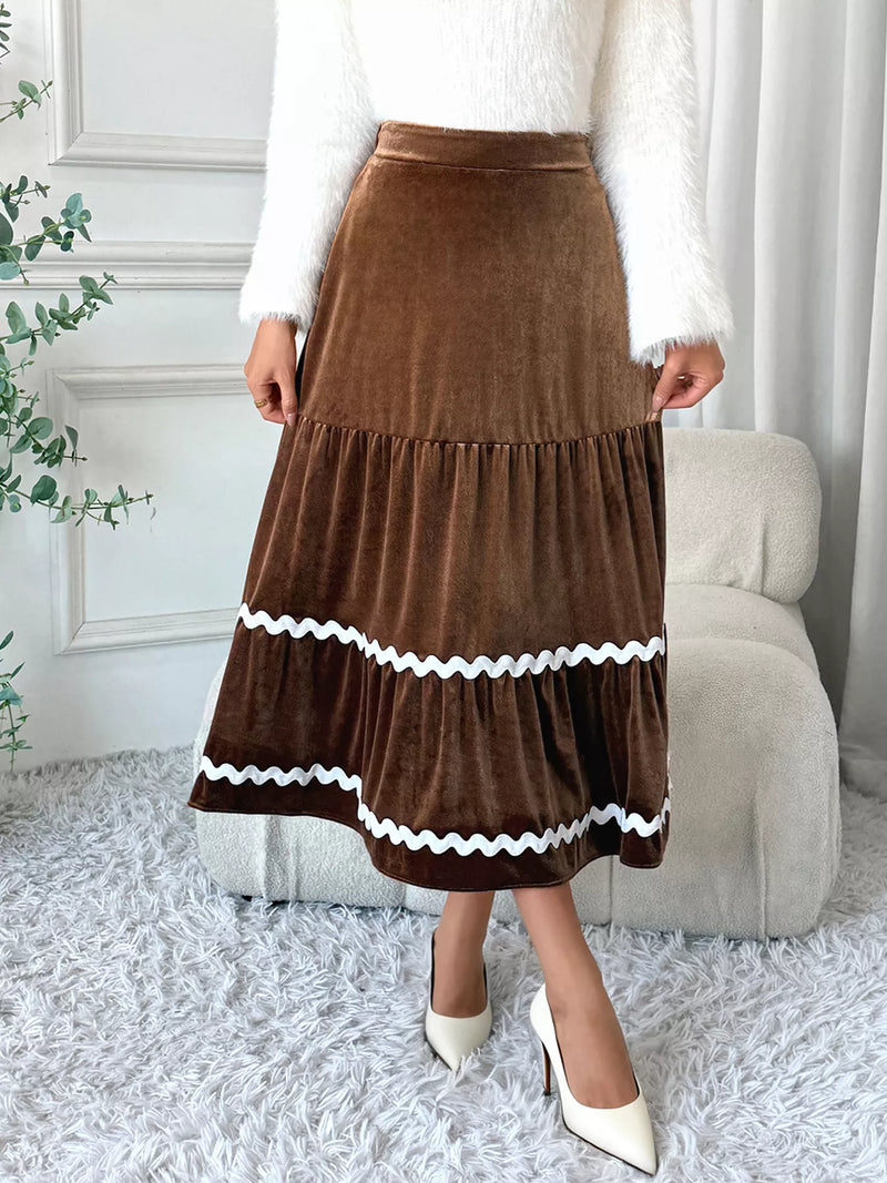 Person wearing a brown skirt with white trim in a home setting