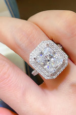 Diamond ring on a finger with a blurred background