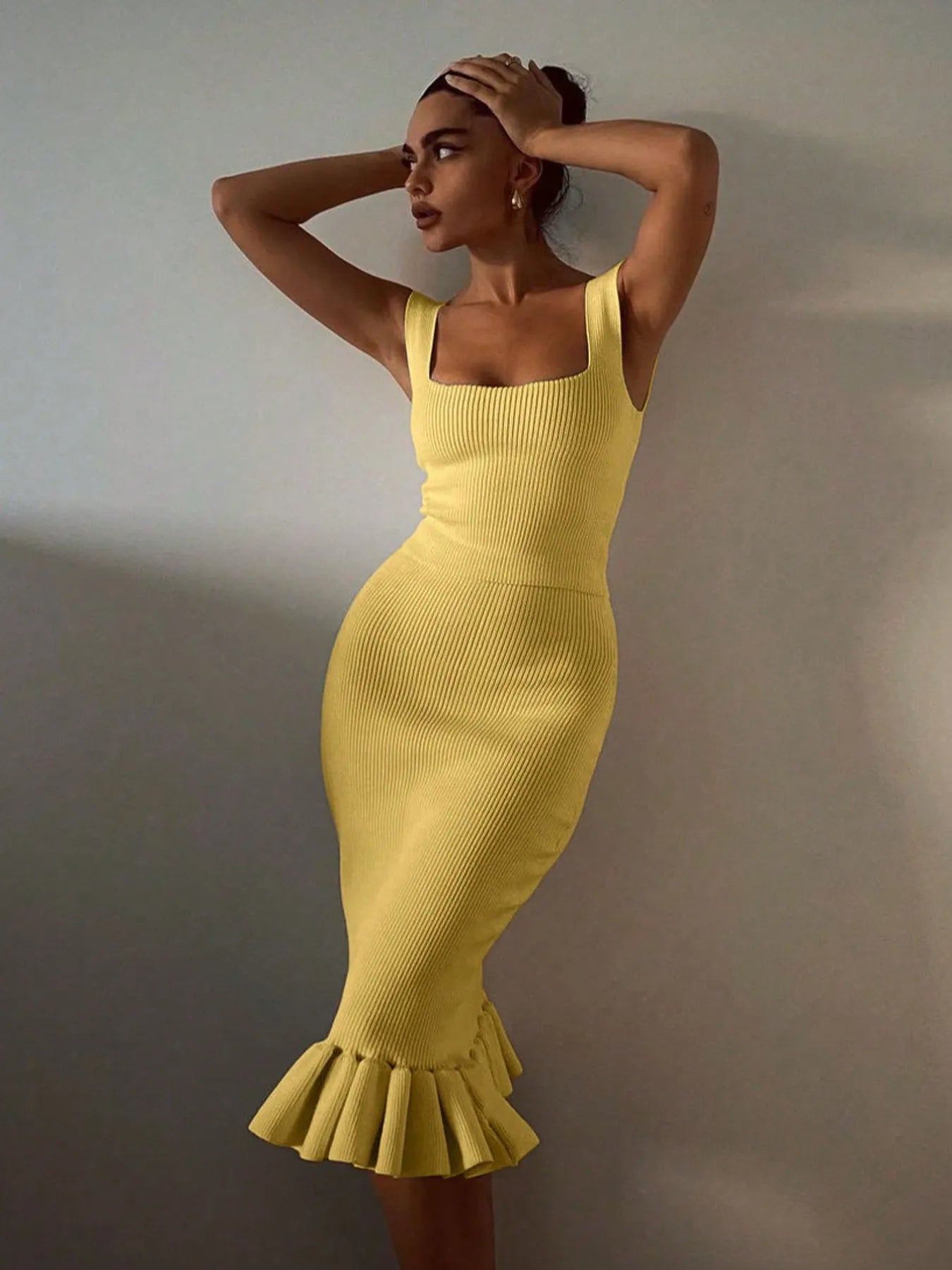 Woman wearing a yellow dress with a plain background