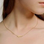 Gold necklace with a cross pendant worn by a person