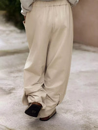 Beige wide-leg pants worn by a person on a concrete surface.