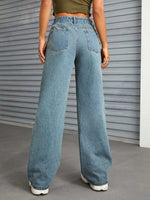 Person wearing blue jeans standing in front of a gray metallic door.