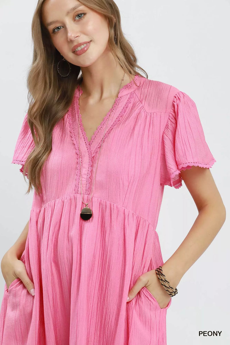 Woman wearing a pink dress with a white background