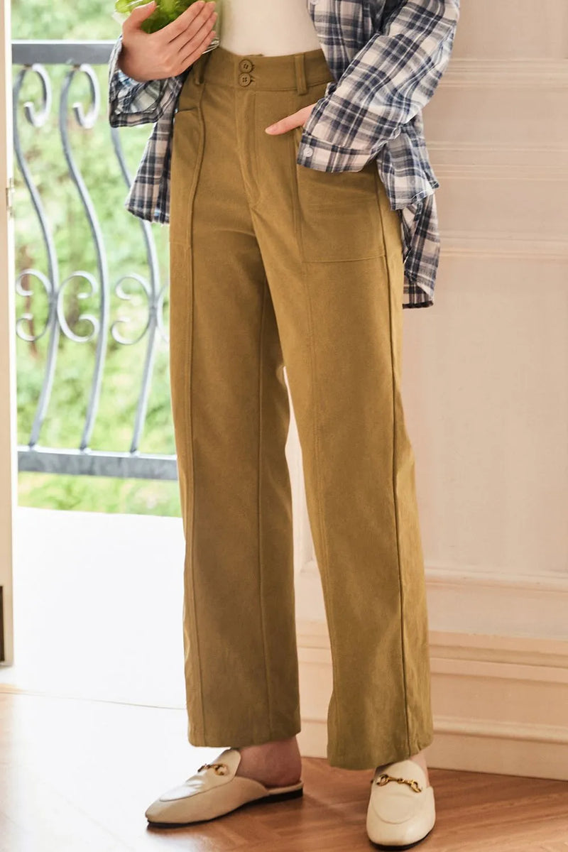 Person wearing mustard yellow pants with a plaid shirt indoors.
