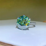 Ring with a large green gemstone on a white surface